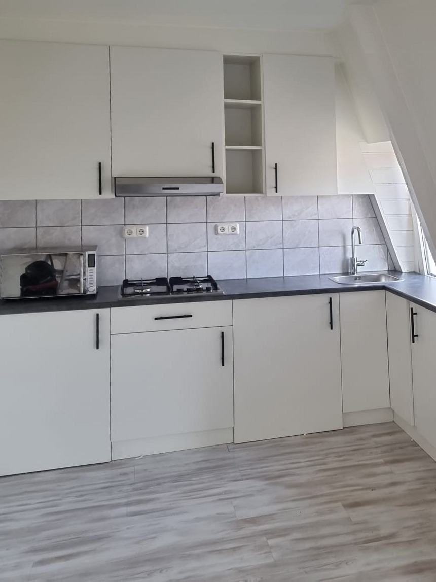 Witte keuken met donker werkblad en grijze wandtegels